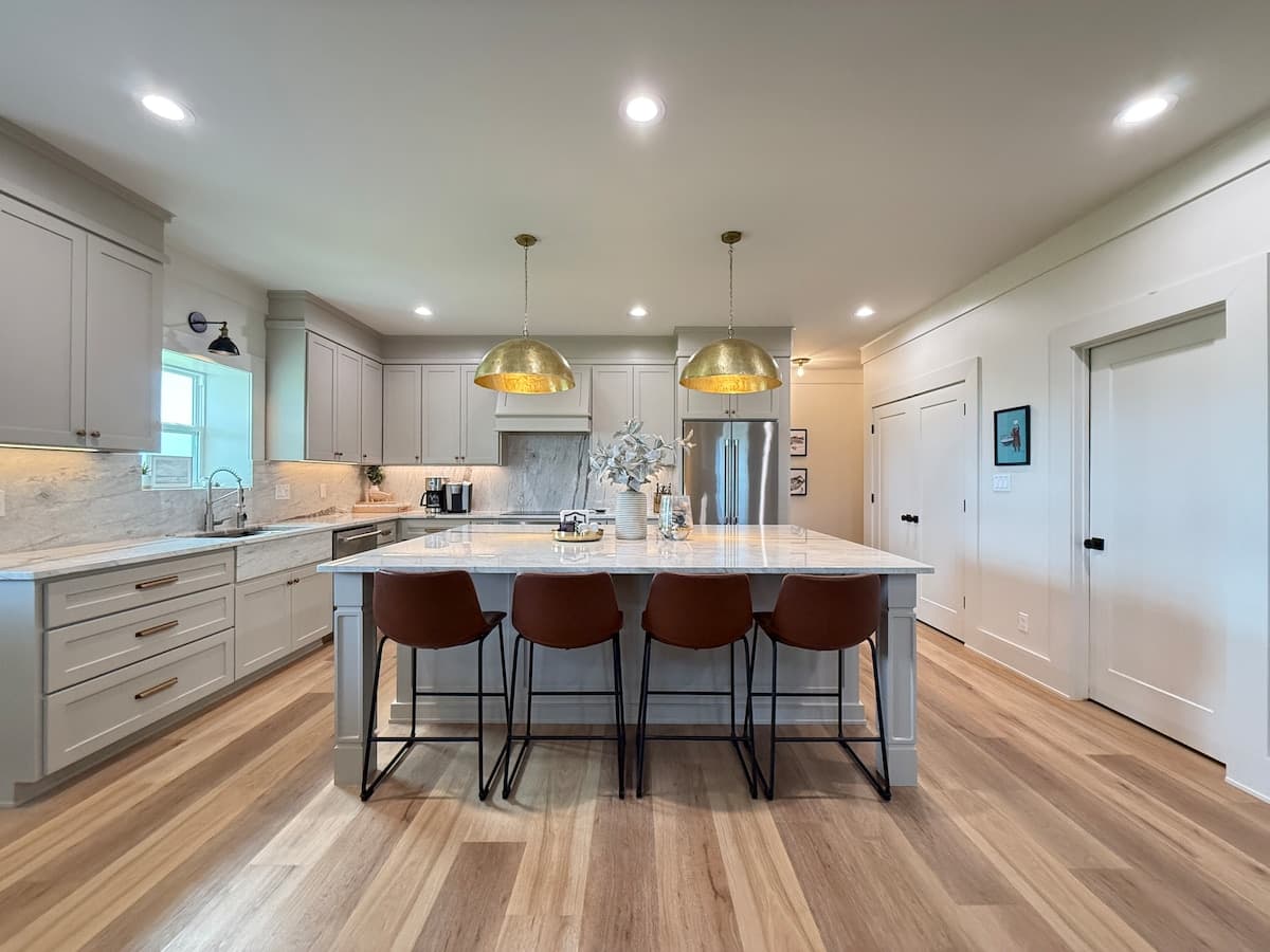 Moonlight Marsh chef's kitchen with marble island and gold pendant lights