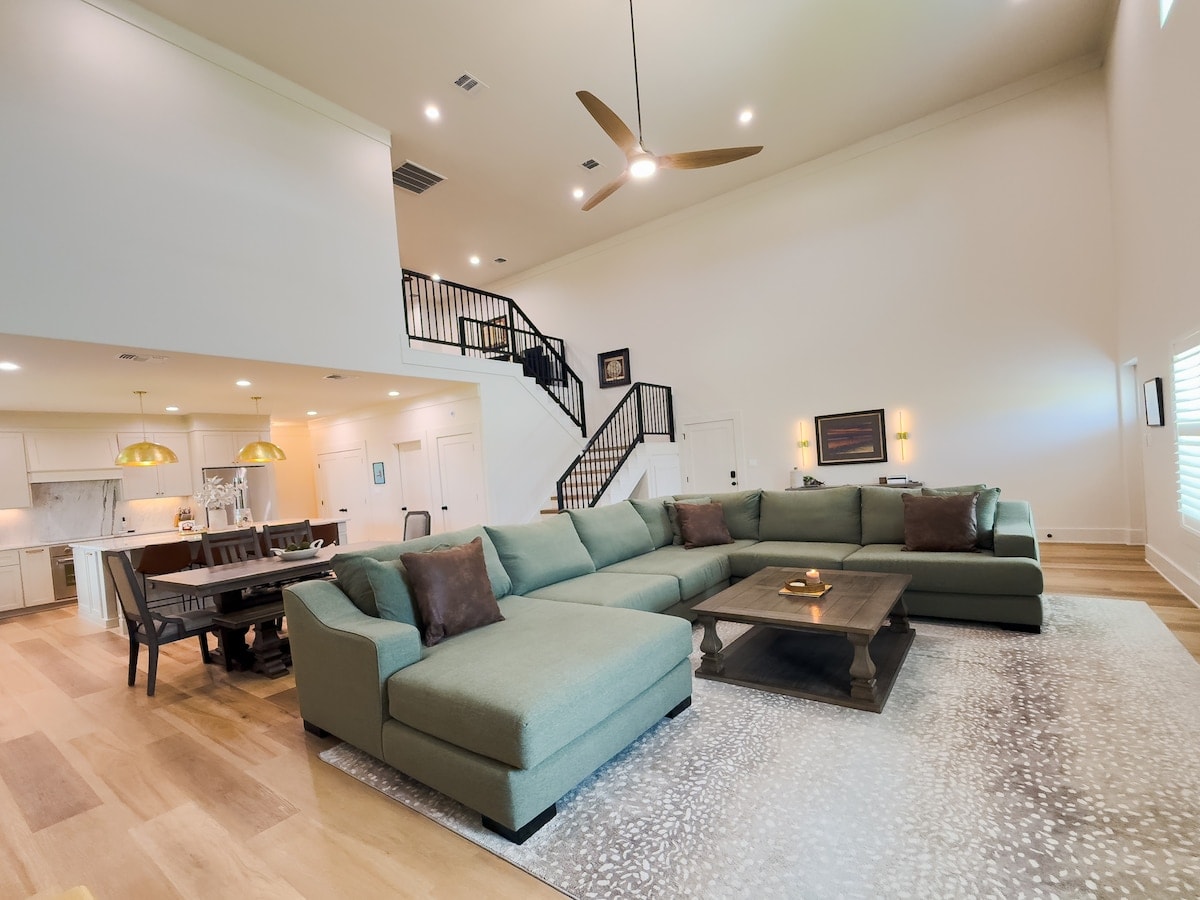 Moonlight Marsh living room with green sectional, open kitchen and upstairs loft